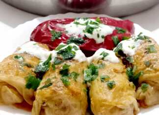 Μια πιατέλα με ζεστούς, λαχταριστούς λαχανοντολμάδες, περιχυμένους με δροσερή σως γιαουρτιού και πασπαλισμένους με φρέσκο άνηθο.