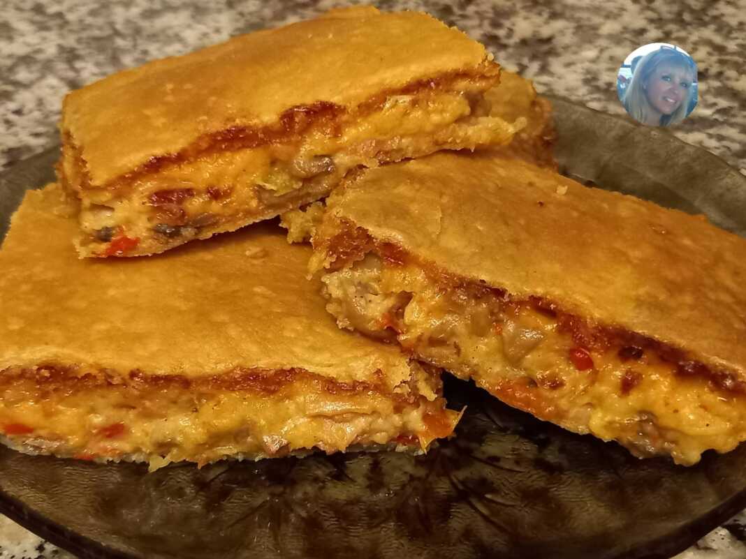 Χρυσαφένια μανιταρόπιτα με μπεσαμέλ, κομμένη σε κομμάτια σε ταψί.