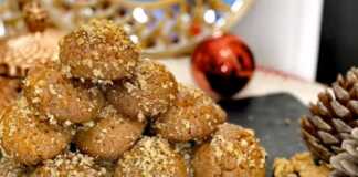 Πιατέλα γεμάτη μελομακάρονα πασπαλισμένα με τριμμένο καρύδι και μέλι, σε γιορτινό φόντο.