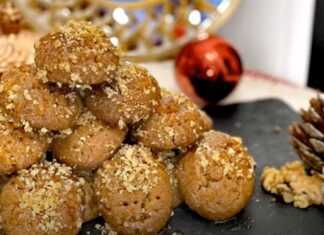 Πιατέλα γεμάτη μελομακάρονα πασπαλισμένα με τριμμένο καρύδι και μέλι, σε γιορτινό φόντο.