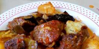 Ζουμερό μοσχαράκι με μελιτζάνες σε πήλινη γάστρα, με λιωμένη γραβιέρα στην επιφάνεια.