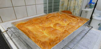 Μπουγάτσα γλυκιά Θεσσαλονίκης συνταγή Ζαχαροπλαστείου Μια φρεσκοψημένη, χρυσαφένια μπουγάτσα Θεσσαλονίκης, κομμένη σε τετράγωνα κομμάτια, πασπαλισμένη με ζάχαρη άχνη και κανέλα.