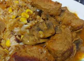 Κομμάτια χοιρινού ψαρονέφρι με λαμπερή, λεμονάτη σάλτσα και μανιτάρια, σερβιρισμένα δίπλα σε ένα πιάτο σπυρωτό πιλάφι με αποξηραμένα φρούτα