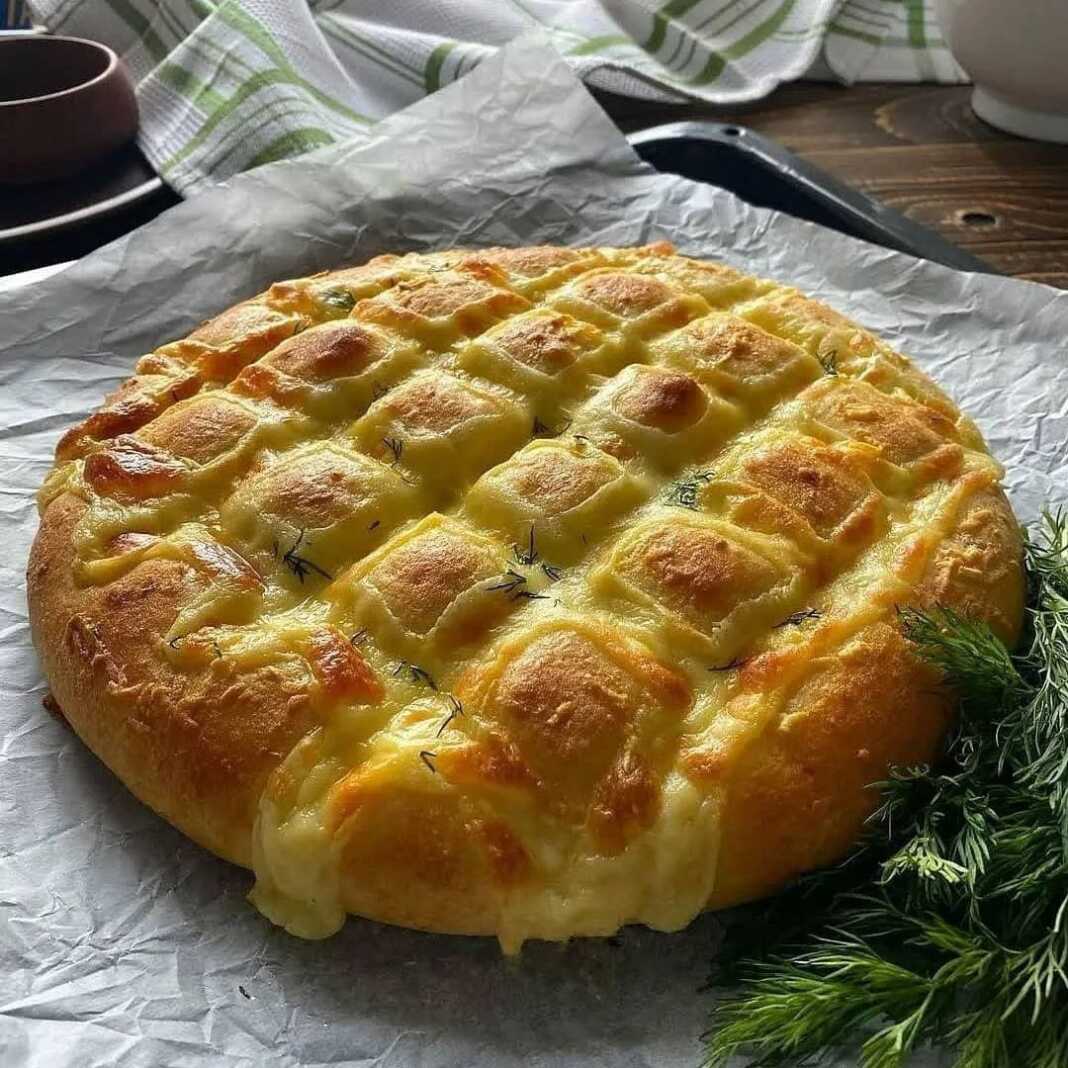 psomitiri Σπιτικό ψωμί με τυρί και μυρωδικά, με χρυσαφένια κρούστα και εμφανείς τις τομές γεμισμένες με τυρί.