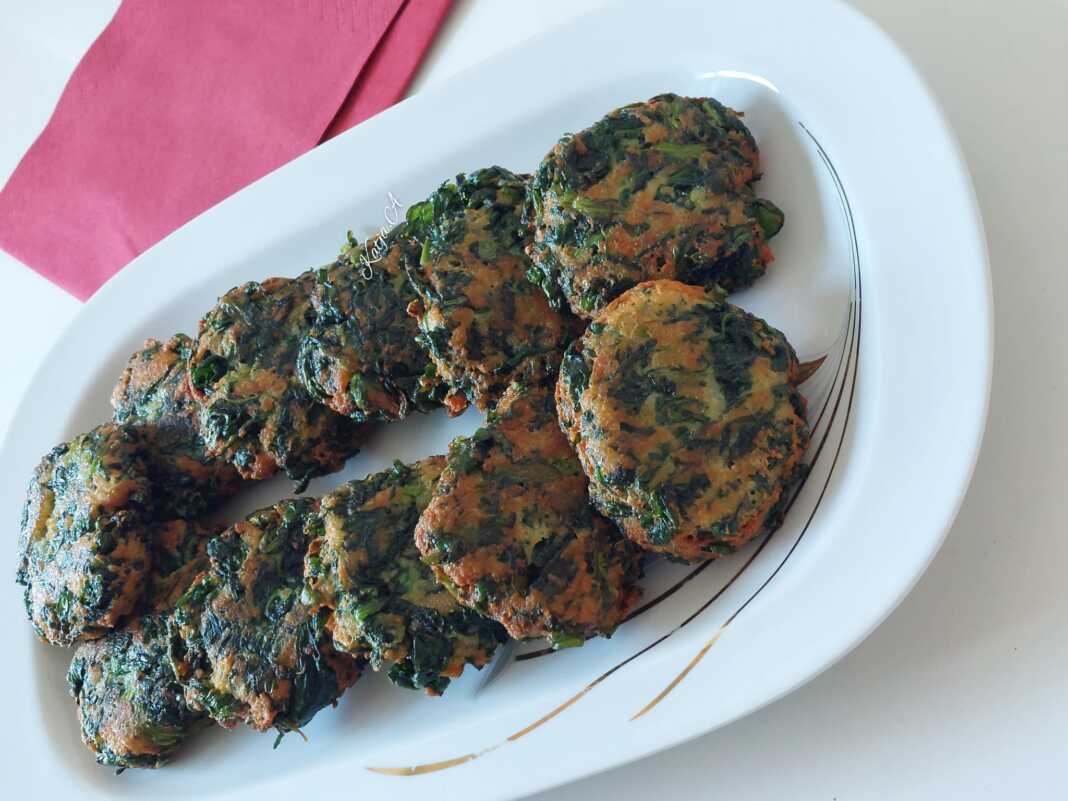 Ένα πιάτο γεμάτο με χρυσαφένιους, τηγανητούς κεφτέδες από σπανάκι, γαρνιρισμένους ίσως με λίγο φρέσκο μαϊντανό.