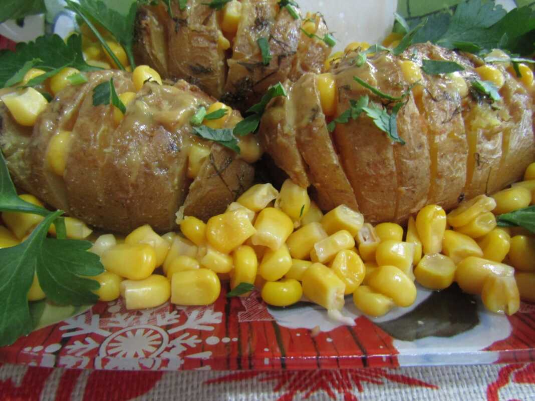 Ολόκληρες πατάτες κομμένες σε λεπτές φέτες σαν ακορντεόν γεμισμένες με καλαμπόκι και αλειμμένες με σάλτσα μουστάρδας μέσα σε ταψί