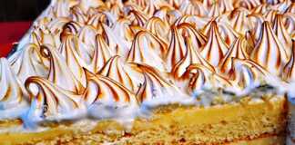 Λεμονόπιτας ταψιού με κίτρινη κρέμα λεμονιού και λευκή καμένη μαρέγκα σε ένα ταψί.