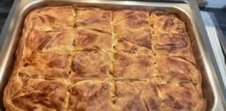 Μια χρυσαφένια, φρεσκοψημένη μακαρονόπιτα με σπιτικό φύλλο, κομμένη σε τετράγωνα κομμάτια, έτοιμη για σερβίρισμα.