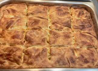 Μια χρυσαφένια, φρεσκοψημένη μακαρονόπιτα με σπιτικό φύλλο, κομμένη σε τετράγωνα κομμάτια, έτοιμη για σερβίρισμα.