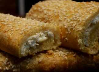 Κοντινό πλάνο σε ένα κομμένο γεμιστό μπαστουνάκι που αποκαλύπτει την πλούσια γέμιση από τυρί.