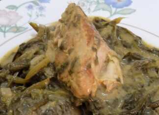 Ένα πλούσιο πιάτο με χοιρινό κρέας και άγρια χόρτα, περιχυμένο με πηχτή σάλτσα αυγολέμονο και φρεσκοτριμμένο πιπέρι