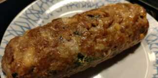 Ρολό κιμά με τυριά, κομμένο σε φέτες, με λιωμένη γέμιση, σερβιρισμένο με πατάτες φούρνου.