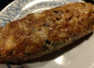 Ρολό κιμά με τυριά, κομμένο σε φέτες, με λιωμένη γέμιση, σερβιρισμένο με πατάτες φούρνου.