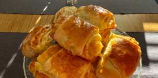 Ένα ταψί γεμάτο χρυσαφένια, φουσκωτά ζαμπονοτυροπιτάκια κομμένα σε ροδέλες, έτοιμα να σερβιριστούν.