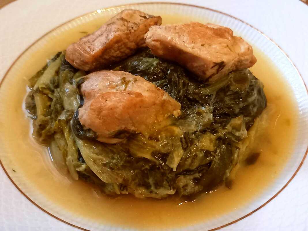 Ένα πιάτο με κοτόπουλο φρικασέ με μαρούλια, περιχυμένο με κρεμώδη σάλτσα αυγολέμονο.