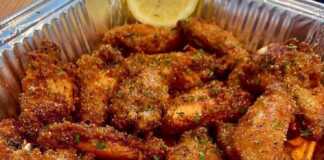 Χρυσαφένιες Λεμονάτες Φτερούγες Κοτόπουλου σε πιατέλα, πασπαλισμένες με φρέσκο θυμάρι