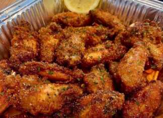 Χρυσαφένιες Λεμονάτες Φτερούγες Κοτόπουλου σε πιατέλα, πασπαλισμένες με φρέσκο θυμάρι