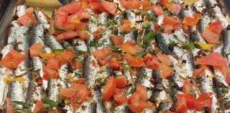 Ένα ταψί με λαχταριστό Γαύρο πλακί, φρεσκοψημένο, με ντομάτες και μυρωδικά.