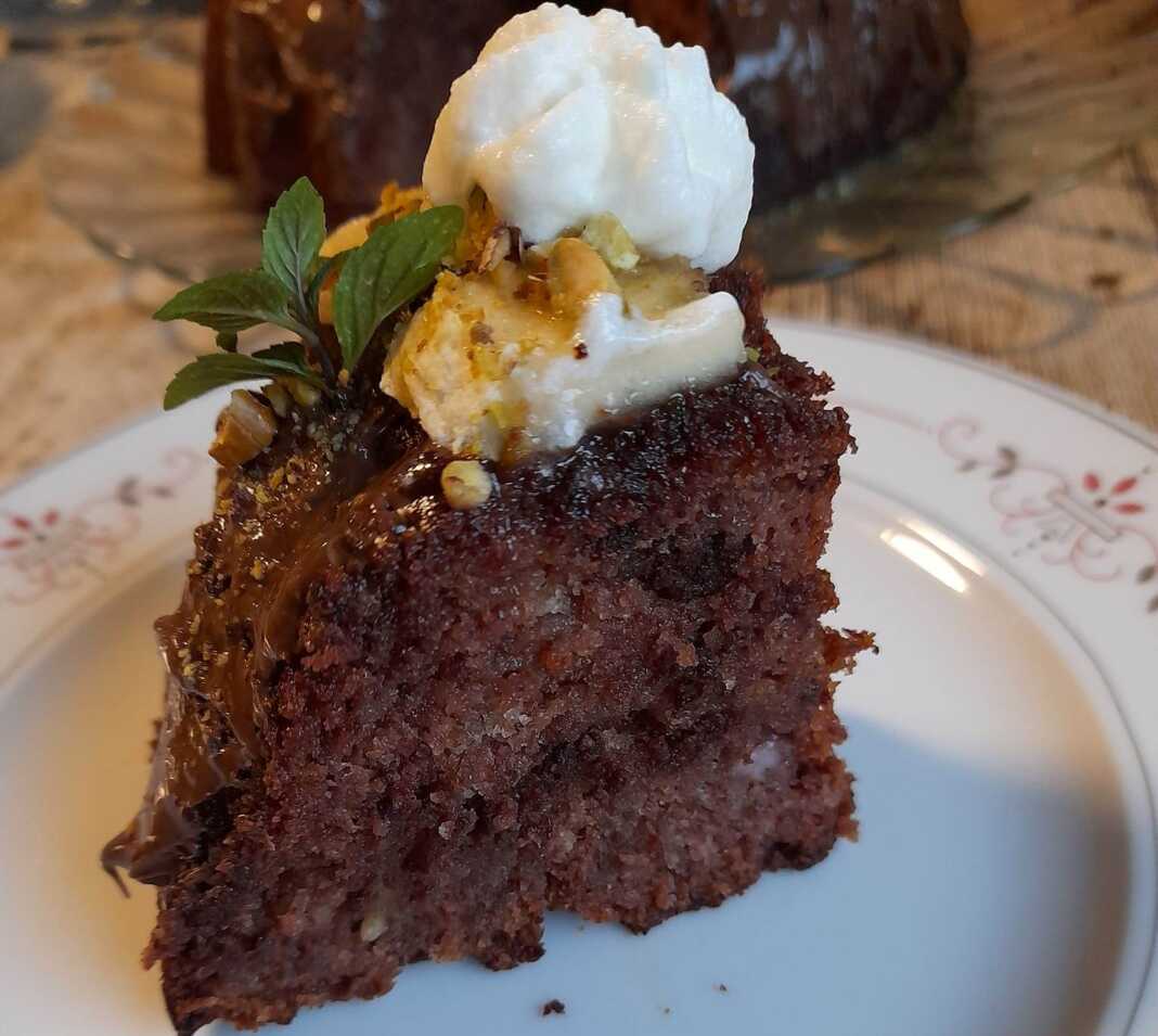 Ένα κομμάτι κέικ μπανάνας σοκολάτας χωρίς αυγά, περιχυμένο με λιωμένη σοκολάτα.