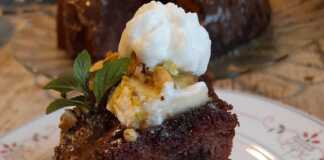 Ένα κομμάτι κέικ μπανάνας σοκολάτας χωρίς αυγά, περιχυμένο με λιωμένη σοκολάτα.