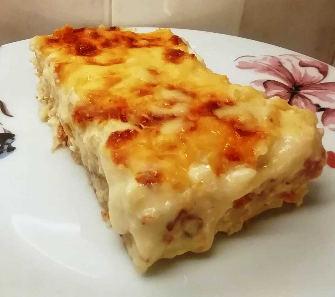 Μακαρονόπιτα χωρίς φύλλο με χρυσαφένια μπεσαμέλ και φέτα, κομμένη σε μερίδες.