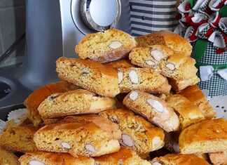 Ένα πιάτο γεμάτο με χρυσαφένια, κομμένα παξιμαδάκια αμυγδάλου, με ορατά κομμάτια αμυγδάλων στην επιφάνεια.