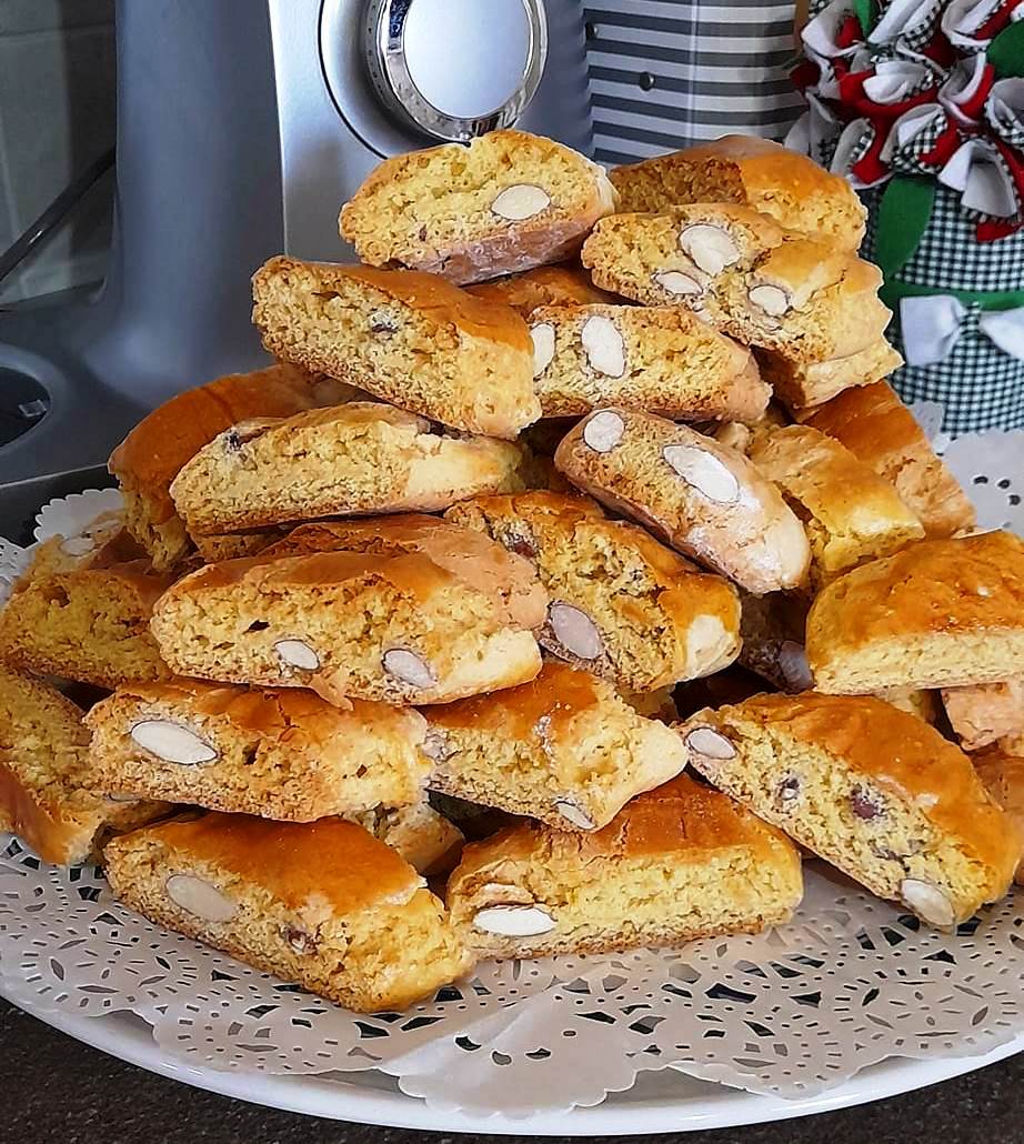 paksimadakia Ένα πιάτο γεμάτο με χρυσαφένια, κομμένα παξιμαδάκια αμυγδάλου, με ορατά κομμάτια αμυγδάλων στην επιφάνεια.