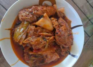 Παραδοσιακό χοιρινό με πράσα και σέλινο στην κατσαρόλα, με μελωμένη σάλτσα ντομάτας και αχνιστό κρέας σερβιρισμένο σε βαθύ πιάτο.