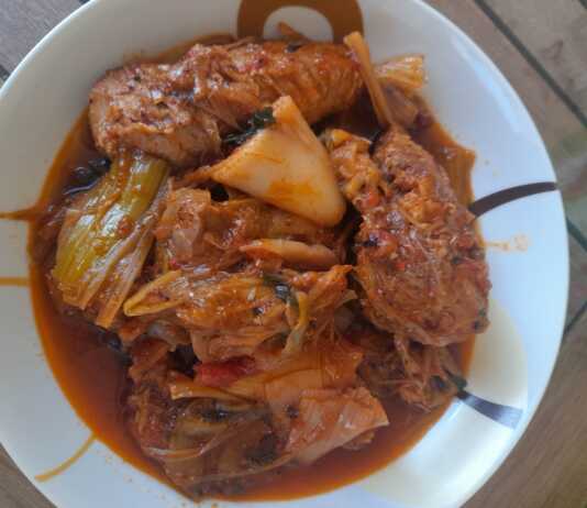 Παραδοσιακό χοιρινό με πράσα και σέλινο στην κατσαρόλα, με μελωμένη σάλτσα ντομάτας και αχνιστό κρέας σερβιρισμένο σε βαθύ πιάτο.