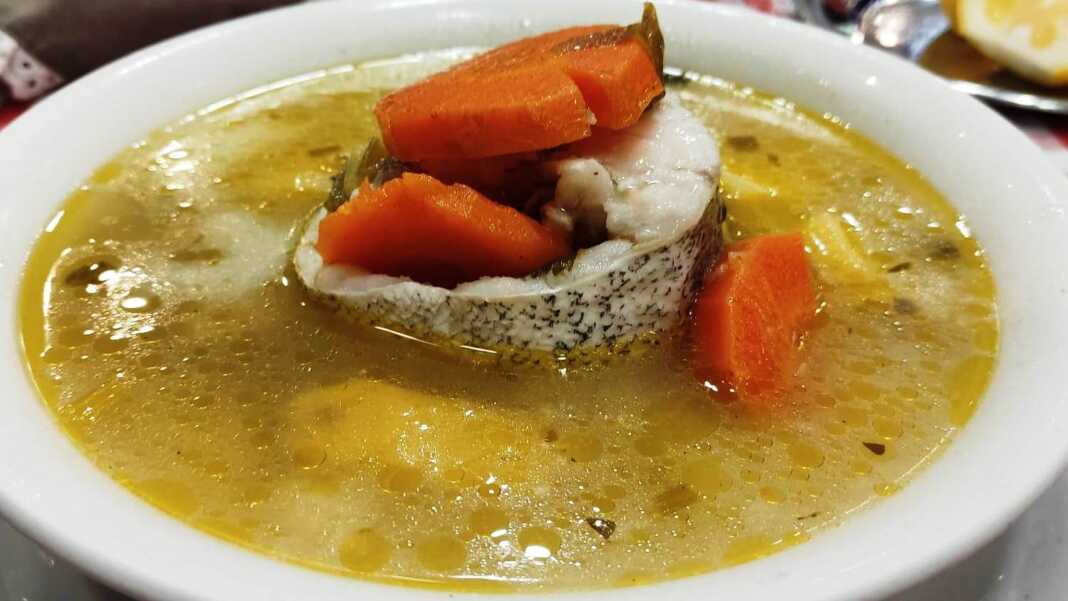 Παραδοσιακή ψαρόσουπα σε βαθύ πιάτο, με κομμάτια ψαριού (μπακαλιάρο), μαλακά λαχανικά (καρότο, σέλινο) και πλούσιο, κίτρινο ζωμό.