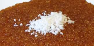 Ένα κομμάτι σιροπιαστό ραβανί με γιαούρτι, πασπαλισμένο με λίγο τριμμένο λεμόνι, σερβιρισμένο σε πιάτο.