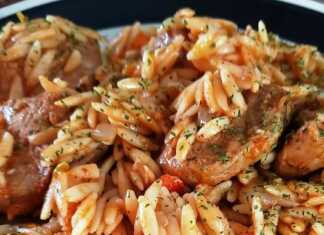 Ένα πιάτο με ζεστό μοσχάρι γιουβέτσι, με κοκκινιστό κριθαράκι, κομμάτια μοσχαριού και πασπαλισμένο με τριμμένο τυρί.