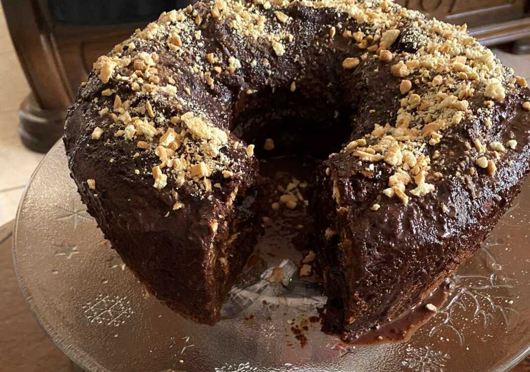 Ένα κέικ Δούκισσα με γλάσο σοκολάτας και γαρνιρισμένο με κομμάτια μπισκότων.