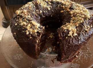 Ένα κέικ Δούκισσα με γλάσο σοκολάτας και γαρνιρισμένο με κομμάτια μπισκότων.