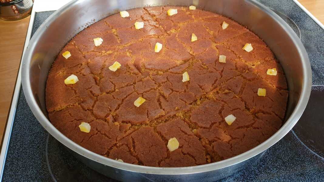 keikMeliou Ένα κομμάτι ραβανί με γιαούρτι σερβιρισμένο, με εμφανή την υφή του σιμιγδαλιού και το σιρόπι.