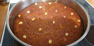 Ένα κομμάτι ραβανί με γιαούρτι σερβιρισμένο, με εμφανή την υφή του σιμιγδαλιού και το σιρόπι.