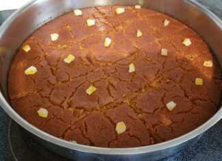 Ένα κομμάτι ραβανί με γιαούρτι σερβιρισμένο, με εμφανή την υφή του σιμιγδαλιού και το σιρόπι.