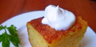 Χρυσαφένιο κέικ σιμιγδαλιού κομμένο σε φέτες σερβιρισμένο με άχνη ζάχαρη και μαρμελάδα δίπλα σε ένα φλιτζάνι καφέ