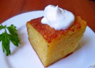 Χρυσαφένιο κέικ σιμιγδαλιού κομμένο σε φέτες σερβιρισμένο με άχνη ζάχαρη και μαρμελάδα δίπλα σε ένα φλιτζάνι καφέ