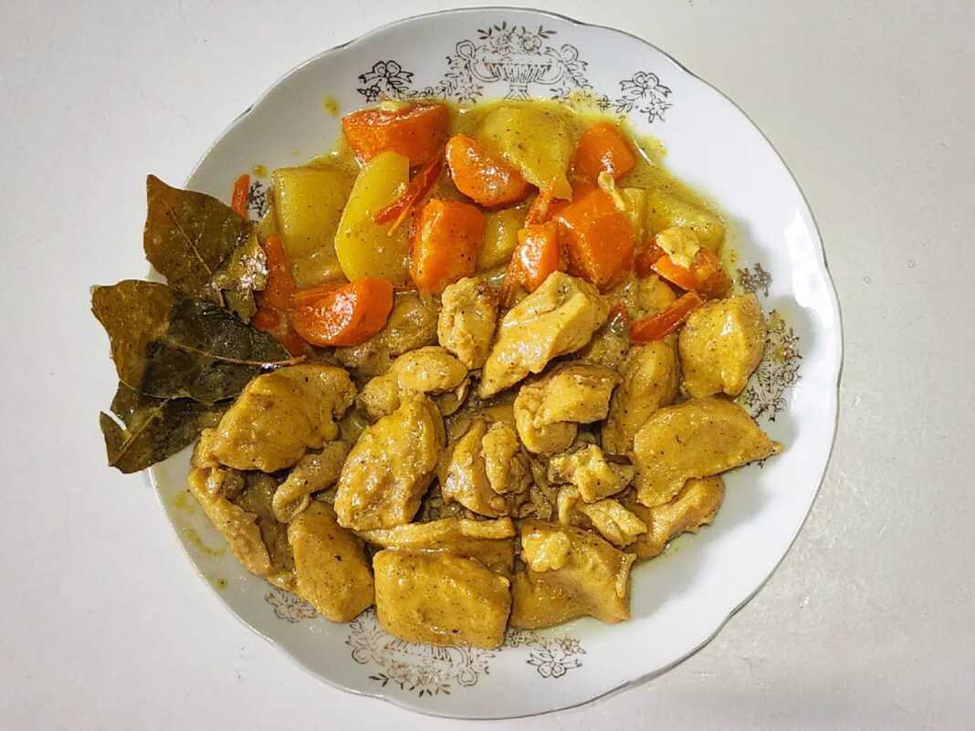 KotopouloKari Ένα πιάτο με κομμάτια κοτόπουλου και κυβάκια πατάτας σε μια πλούσια, κρεμώδη σάλτσα κάρυ.