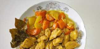 Ένα πιάτο με κομμάτια κοτόπουλου και κυβάκια πατάτας σε μια πλούσια, κρεμώδη σάλτσα κάρυ.