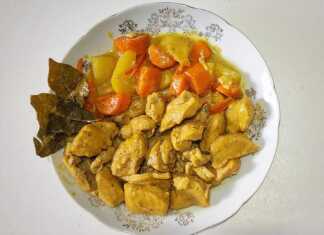 Ένα πιάτο με κομμάτια κοτόπουλου και κυβάκια πατάτας σε μια πλούσια, κρεμώδη σάλτσα κάρυ.