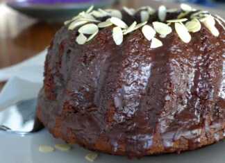 Αφράτο νηστίσιμο σοκολατένιο κέικ περιχυμένο με γυαλιστερό γλάσο σοκολάτας, πασπαλισμένο με φέτες αμυγδάλου