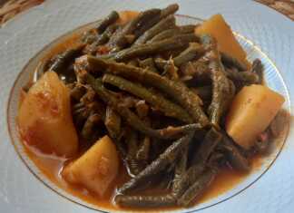 Ένα πιάτο με καταπράσινα αμπελοφάσουλα κοκκινιστά, μελωμένες πατάτες και πλούσια κόκκινη σάλτσα, σερβιρισμένο με ένα κομμάτι φέτα