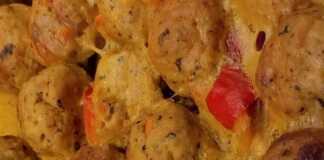 Πιάτο με ροδοκόκκινα κεφτεδάκια κοτόπουλου φούρνου περιχυμένα με χρυσαφένια σάλτσα μουστάρδας, γαρνιρισμένα με ψιλοκομμένες πιπεριές.