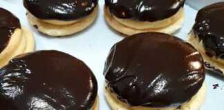 Ένα πιάτο γεμάτο με στρογγυλά κοκάκια, με τη μία πλευρά καλυμμένη με γυαλιστερό γλάσο σοκολάτας, που δείχνουν την κρεμώδη γέμιση στο εσωτερικό.