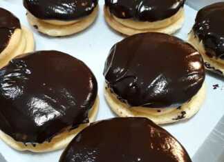 Ένα πιάτο γεμάτο με στρογγυλά κοκάκια, με τη μία πλευρά καλυμμένη με γυαλιστερό γλάσο σοκολάτας, που δείχνουν την κρεμώδη γέμιση στο εσωτερικό.