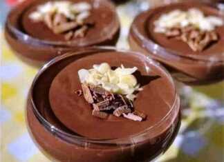 Οκτώ μικρά γυάλινα μπολάκια γεμάτα με σκούρα, αφράτη μους σοκολάτας, καλυμμένα με λευκή σαντιγί και πασπαλισμένα με τριμμένη σοκολάτα.