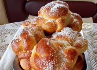 Ένα μικρό γυάλινο βαζάκι γεμάτο με φρέσκια, κίτρινη σπιτική μουστάρδα δίπλα σε λεμόνια και σκόνη μουστάρδας.