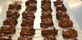 Βραχάκια από ακανόνιστα σοκολατένια κομμάτια με καραμελωμένους ξηρούς καρπούς πάνω σε λαδόκολλα.